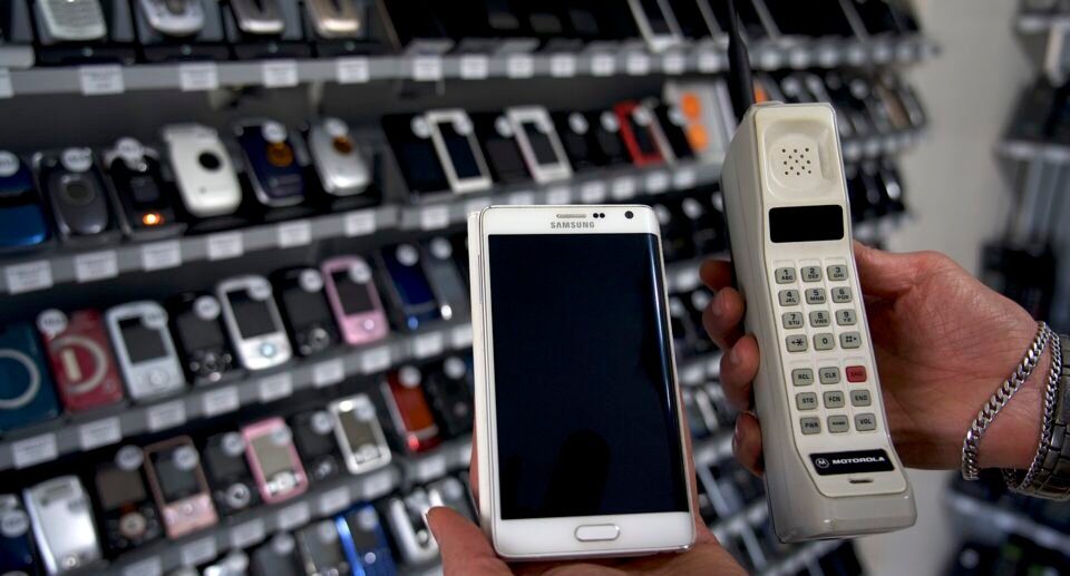 A 1980s Motorola DynaTAC mobile phone next to a modern Samsung Galaxy smartphone